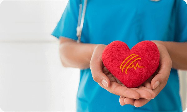 Nurse craddling a red stuffed heart with Supplemental Health Care's logo