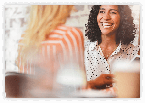 candid photo of two women smiling and talking.