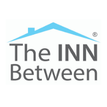 Logo with the text "The INN Between" under a blue roof outline and a small chimney on the left side.
