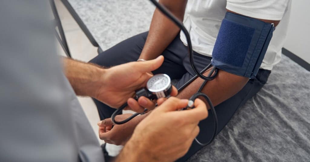 A healthcare professional measures a patient's blood pressure using a sphygmomanometer.