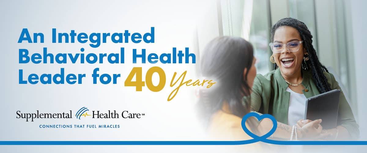 Two people conversing cheerfully in an office setting. Text reads: "An Integrated Behavioral Health Leader for 40 Years. Supplemental Health Care. Connections That Fuel Miracles.